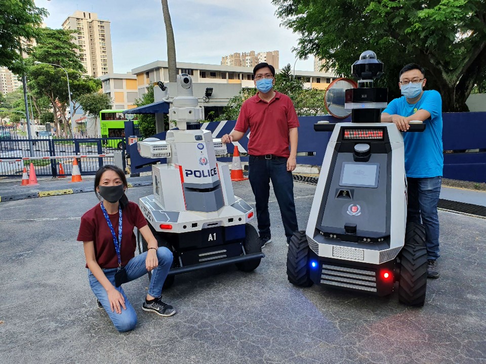 A group of people posing with a robot.
