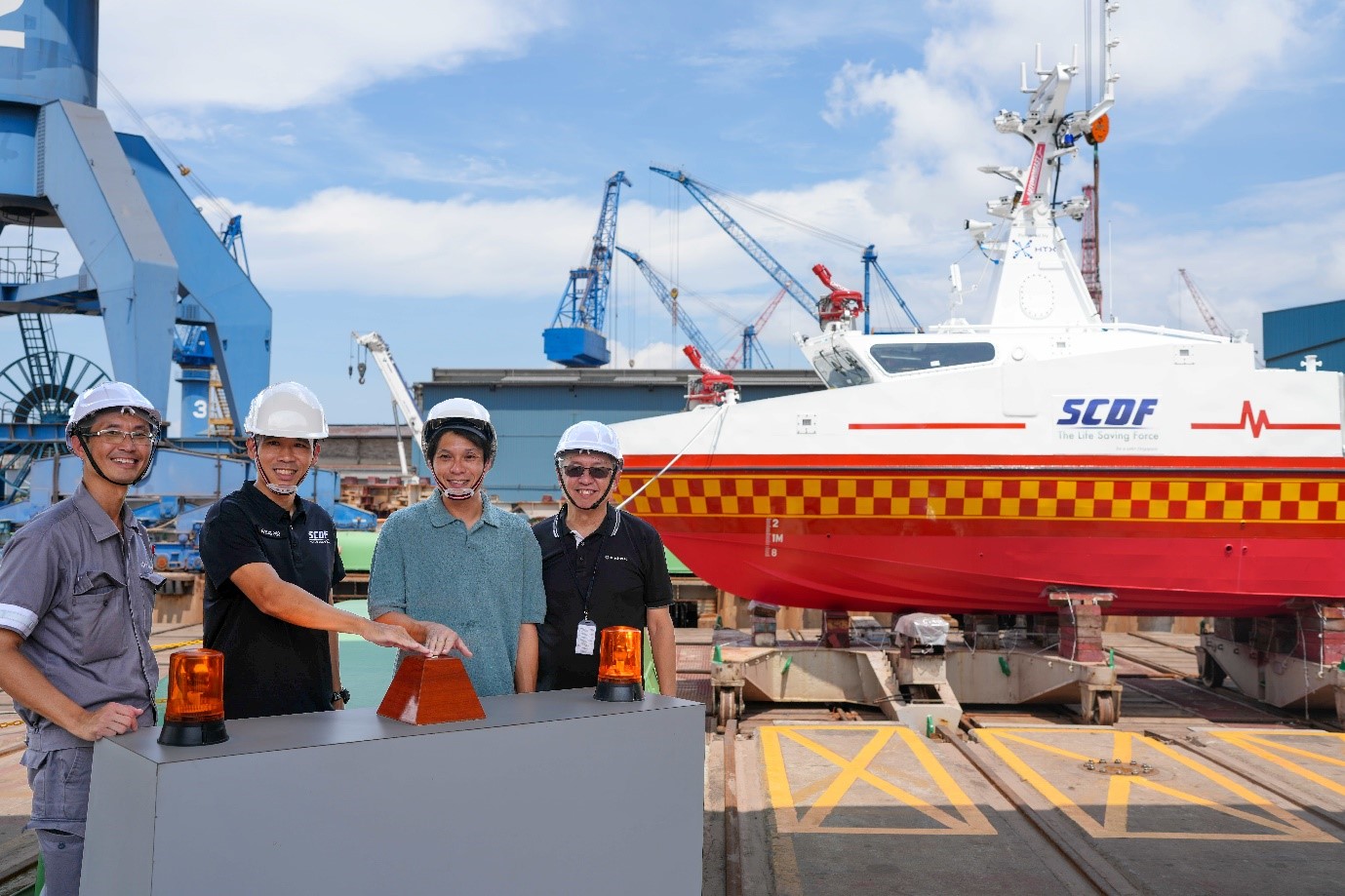 Four men stand in front of a boat.