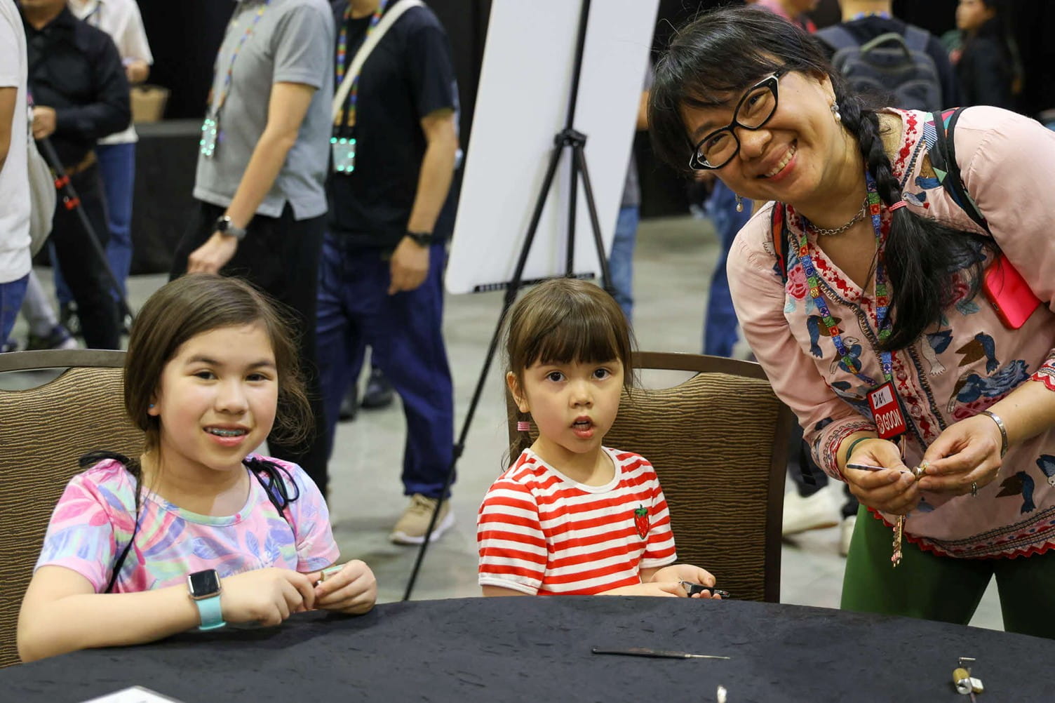 A woman and two kids smiling at the camera.