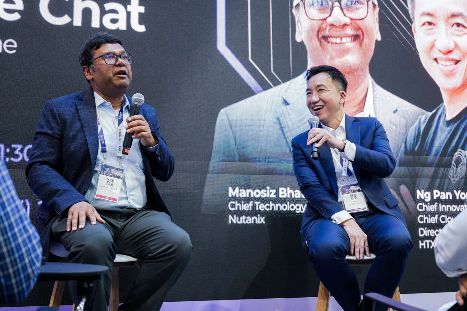 Two men speaking at a tech conference panel.