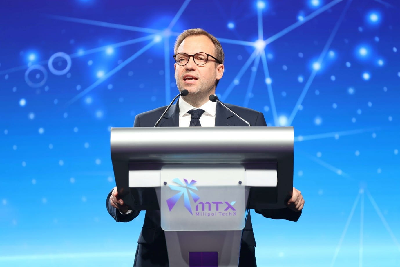 Man speaking at a podium with a microphone.