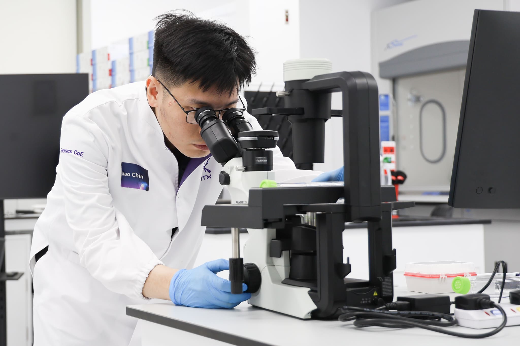 A man looking through a microscope.
